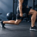 Ejecución de una zancada frontal vista de perfil en el gimnasio